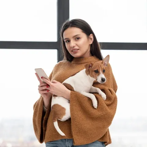 Woman carrying a jack russell terrier